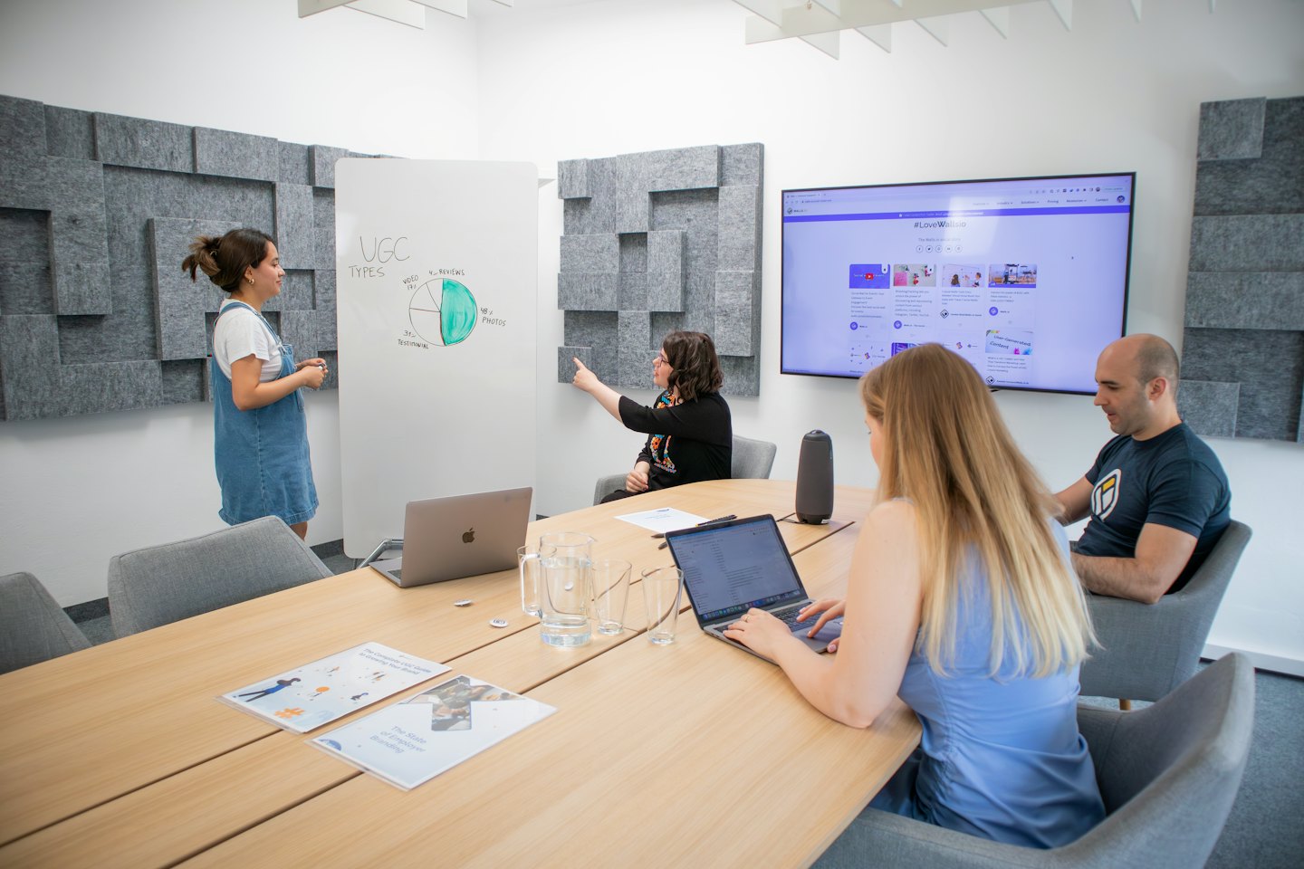 Team collaborating in a modern office meeting room with a presentation.